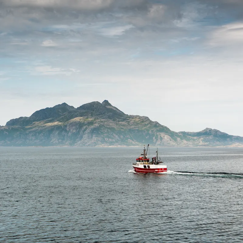 Fishing boat below the mountain
