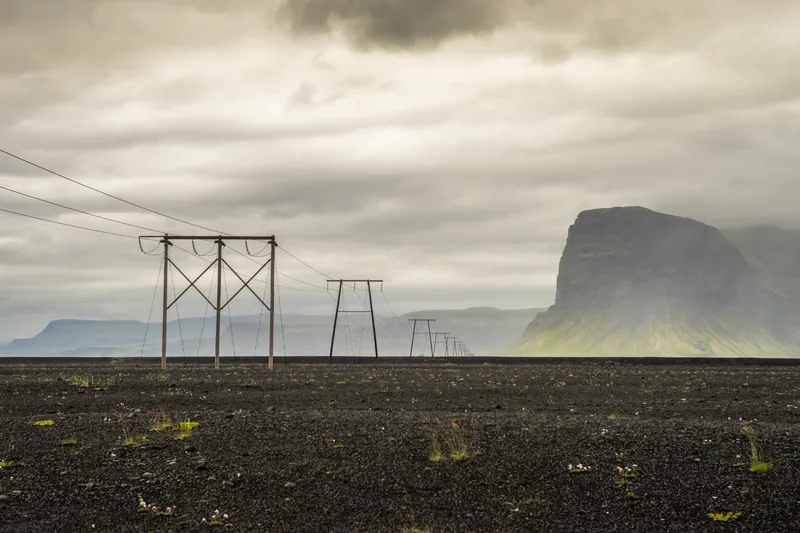 Power lines across black sand