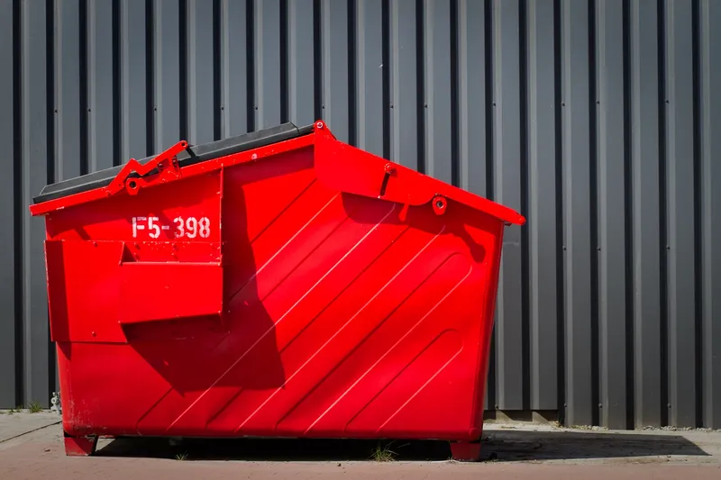 Red skip against grey steel